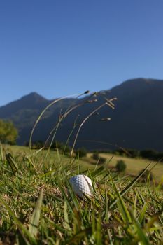 Golf Ball on a golf course with a mountain range in the background