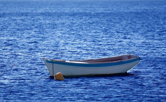 A small wooden boat anchored in the bay