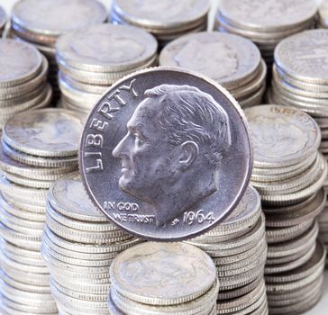 Pre 1964 dimes were 90% pure silver and are collectible. A good example of a Roosevelt dime against a stacks of similar silver dimes