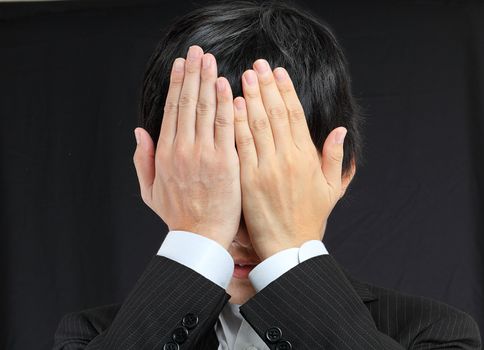 businessman covering his face by hands 