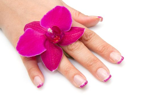 Beautiful hand with perfect nail french manicure and purple orchid flowers