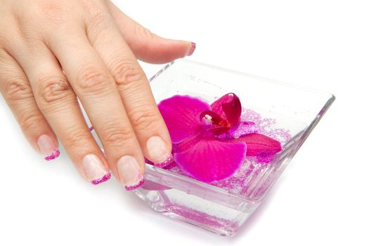 Beautiful hand with perfect nail french manicure and purple orchid flowers