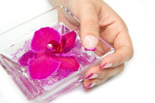 Beautiful hand with perfect nail french manicure and purple orchid flowers