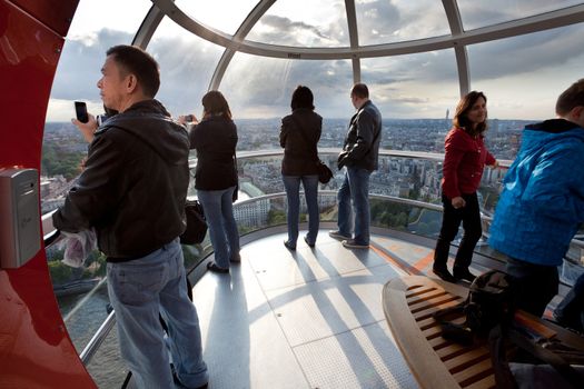 LONDON - JUNE 10: Tourists in the London eye cabin observing city from birds view on June 10, 2011, Londun, UK. Millennium Wheel is the tallest Ferris wheel in Europe 135-metre (443 ft), and the most popular paid tourist attraction in the United Kingdom