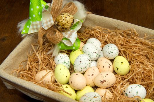 Colorful chocolate easter eggs in brown basket 
