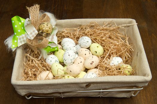 Colorful chocolate easter eggs in brown basket 