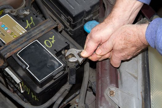 mechanic changing the battery of a car 