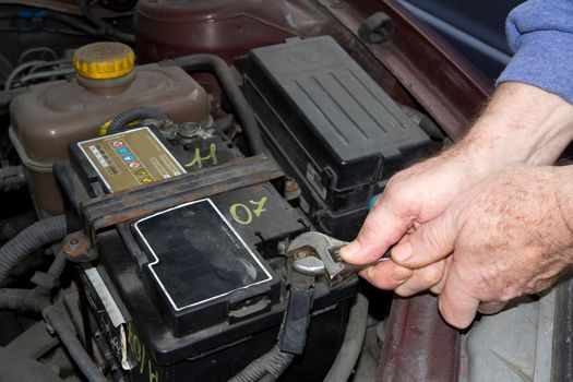 mechanic changing the battery of a car 