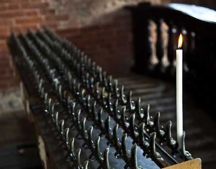 Lonely candle in a Italian Abbey. Concept of hope, faith, loneliness