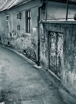 Small scary street with old grunge walls and buildings