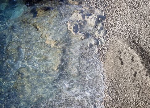 Beautiful rocky beach with some footprints on the sand