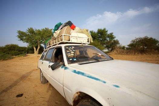 Over loaded taxi on a road of Mali