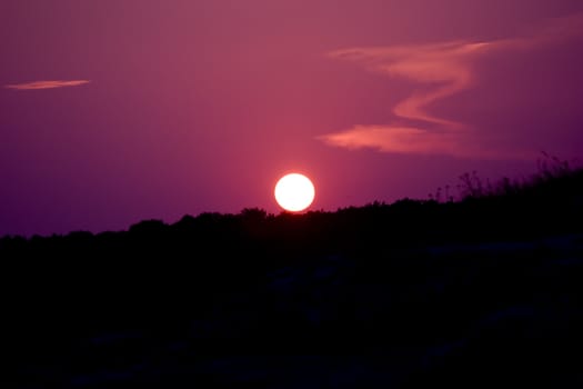 Purple sunset above the small hill