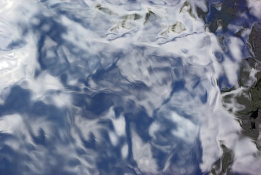 Water surface with reflection of sky and clouds on it
