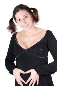 Pregnant woman holding her hands in form of heart sign on her belly