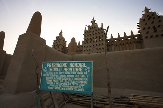 The big mosque in Djenné  and the traditional mud building in Mali - Unesco information signboard. 