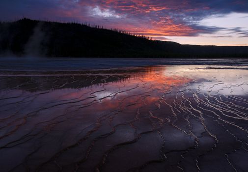 Geyserite patterns and forested ridge at sunset, Grand Prismatic Spring, Yellowstone National Park, Wyoming