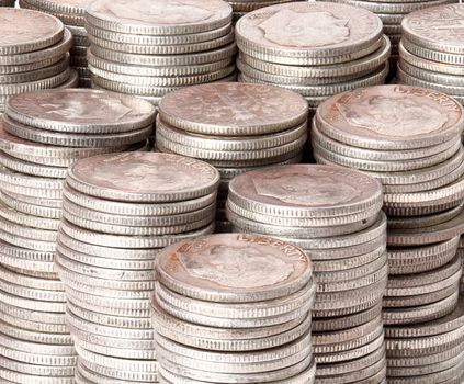 Many stacks of old silver dimes face on to camera