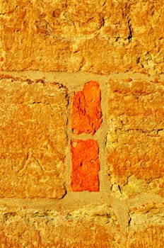 Closeup of an old wall in gold and orange.