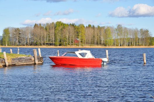 Red and white motorboat in a lake in Sweden.