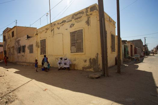 Sunday afternoon in Saint-Louis, Senegal. 2 man and a few kids in the street