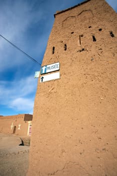 Old Moroccan house with a signboard to the musem with blue sky