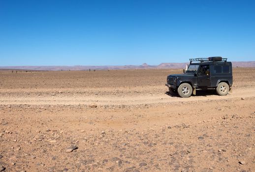 A four wheel drive car on a desert road in Morocco