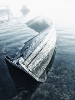 Old abandoned sunken wooden boat in the bay