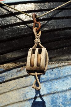 Old wooden block hanging on the side of a boat.