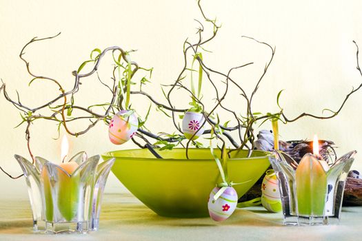 Easter decoration with branches, green bowl and candles