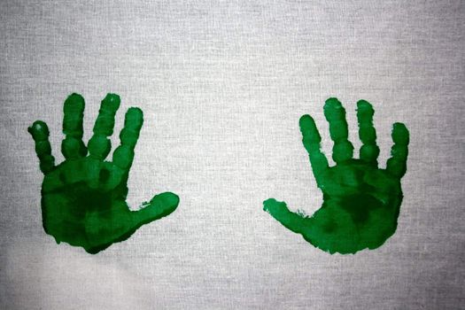 Green handprint in paint of two children's hands