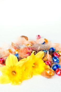 Easter decoration - chocolate eggs, daffodils and feathers - vertical
