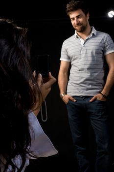 Girl taking photos of her boyfriend in a studio environment