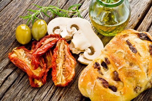 dried red tomato on wood with bread and olive oil