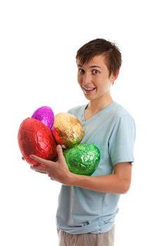 An excited boy holds variety of colourful foil wrapped chocolate easter eggs