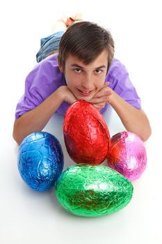 A young boy smiling with easter eggs on a white background.