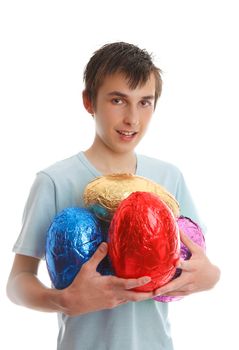 A teen boy holding four large chocolate easter eggs in his arms.  White background.
