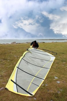 windsurfer getting equipment ready on the beach in the maharees county kerry ireland