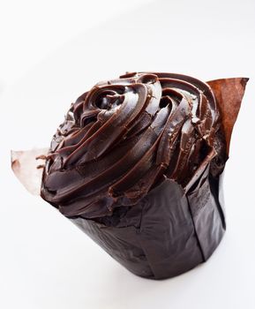 Iced chocolate cupcake on a white dish