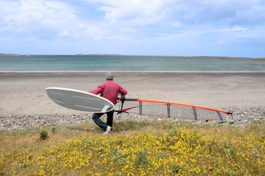 windsurfer getting equipment ready on the beach in the maharees county kerry ireland