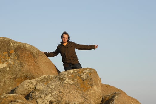 young man with arms wide open and the sky as background