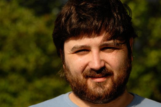 young man portrait with some vegetation as background