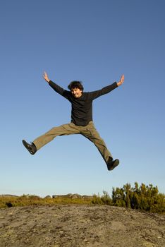 young man jumps high in the mountain