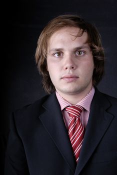 young business man portrait on black background