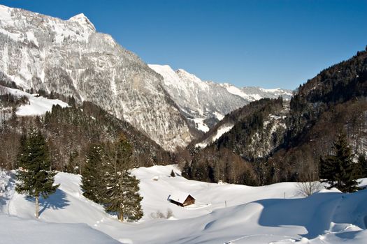 Lonely house on a snowy winter morning in the Swiss Alps.