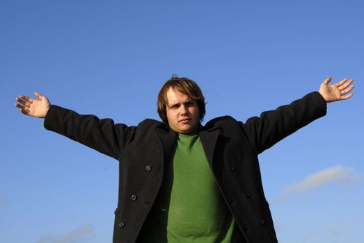 man with open arms with the sky as background