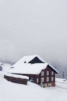 A typical Swiss house covered with snow, in the Alps.