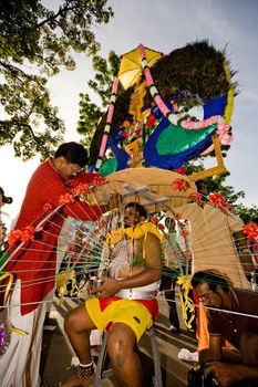 man preparing to carry a heavy kavadi decorated to please the deity
