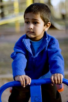 A child playing thoughtfully in a local park