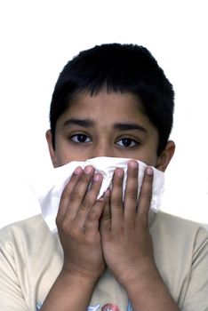 A young handsome boy with a tissue to his nose nurses a cold